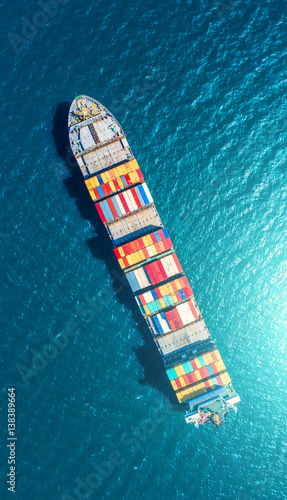 container ship in import export and business logistic.By crane ,Trade Port , Shipping.cargo to harbor.Aerial view.Top view. © MAGNIFIER
