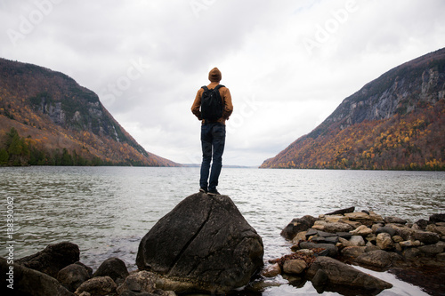 Rear view of man standing on rock looking away at view