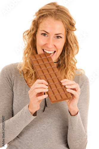 Cute young woman eating chocolate isolated over white background