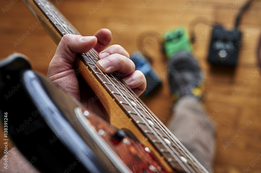a person playing a guitar and using effect pedals a person playing a guitar and using effect pedals