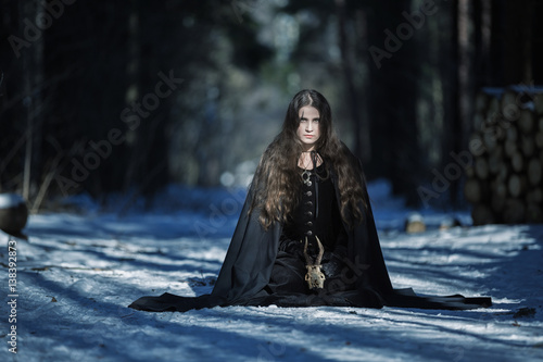 Fotografia The witch with a skull in the forest