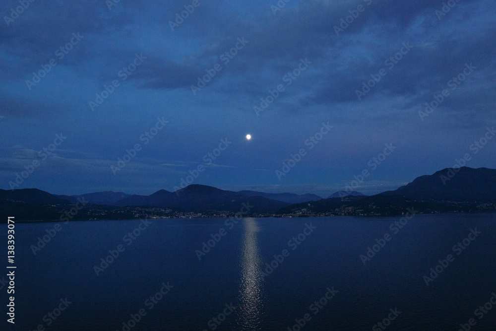 Beautiful evening landscape. Lunar path on lake and mountain