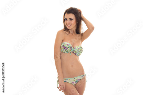 young sexy brown hair lady with big natural breasts in swimsuit with floral pattern looking and smiling on camera isolated on white background