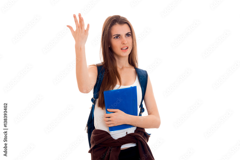 stylish angry brunette student girl with blue backpack and folder for notebooks in her hands screaming and looking away isolated on white background stylish angry brunette student girl with blue backpack and folder for notebooks in her hands screaming and looking away isolated on white background