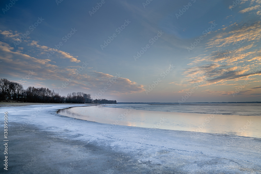 The sun set over the frozen lake