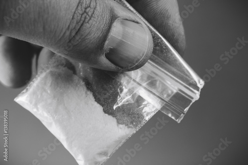 фотографія Mans hand holding or giving plastic packet with portion of cocaine