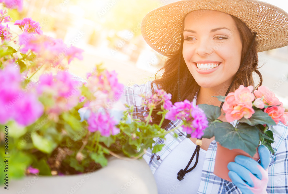 Happy Young Adult Woman Wearing Hat and Gloves Gardening Outdoors.