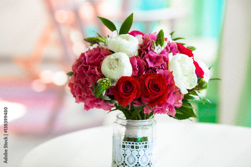 Obraz premium Wedding bouquet roses and peonies in glass vase on table