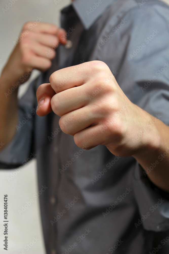 Fototapeta premium young man in boxing pose with fists up dressed nicely.
