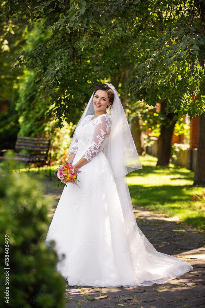 Beautiful bride posing in park without groom at wedding day Beautiful bride posing in park without groom at wedding day