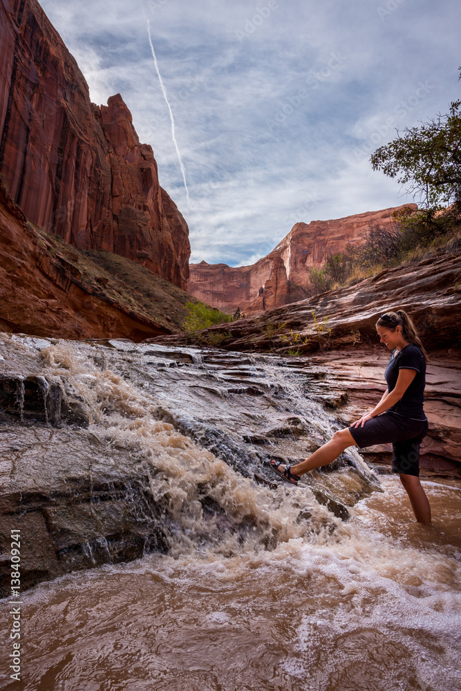 Hiker near  Small Waterfall in Coyote Gulch Grand Staircase Escalante National Monument