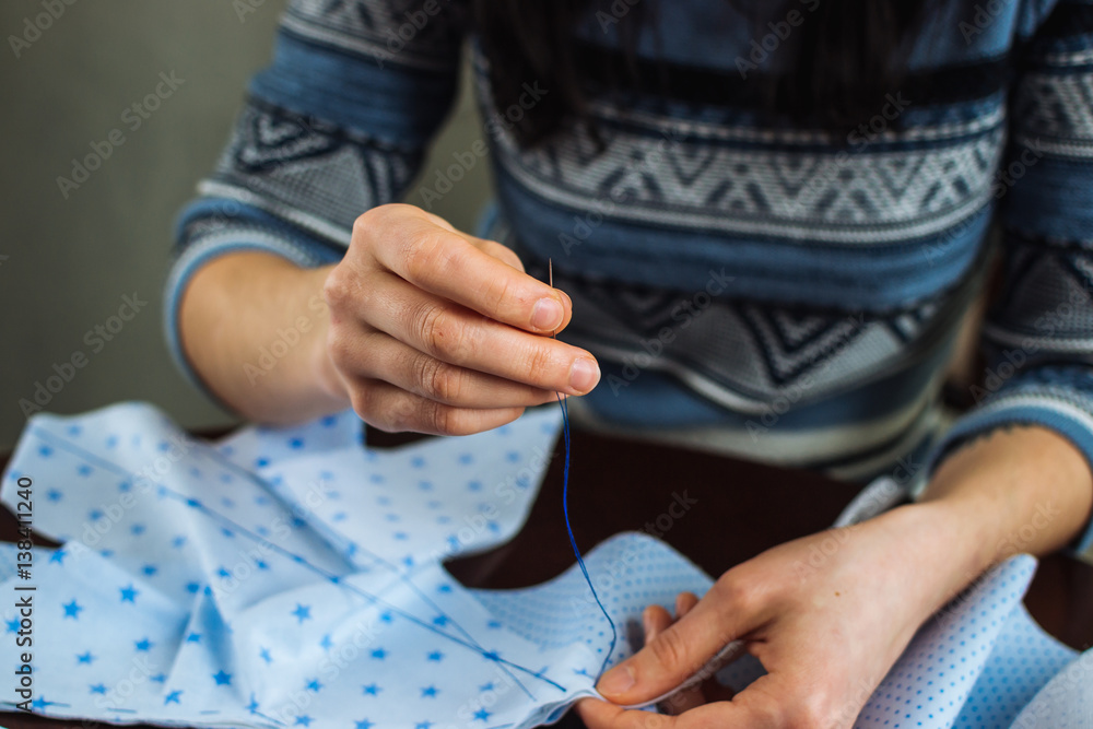 Fototapeta premium Young woman handsewing, close up view