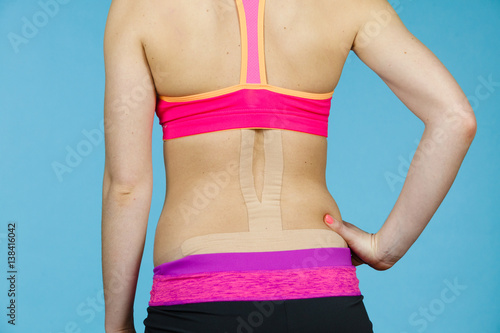 Woman with medical kinesio taping on back