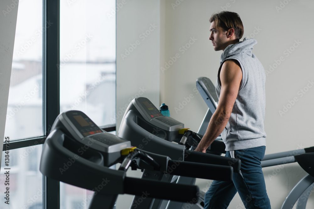 Young man exercising on treadmill at the gym Young man exercising on treadmill at the gym