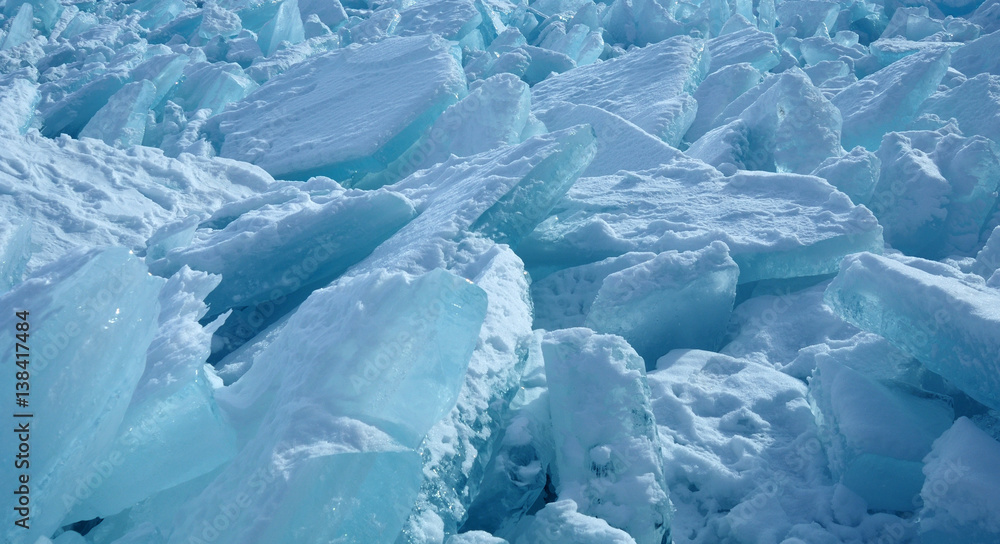 ice hummocks on the northern shore of Olkhon Island on Lake Baikal. Transparent blocks of crystal clear ice crawl ashore. Colorful refraction of rays of rising sun. Ice Storm. Photo partially tinted. ice hummocks on the northern shore of Olkhon Island on Lake Baikal. Transparent blocks of crystal clear ice crawl ashore. Colorful refraction of rays of rising sun. Ice Storm. Photo partially tinted.