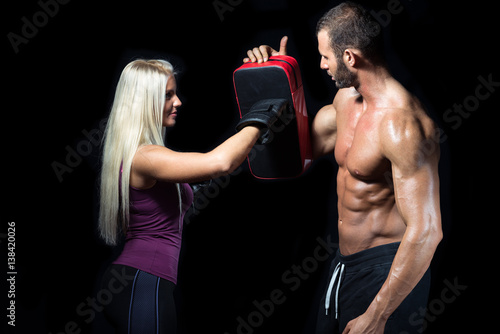 Blonde woman punching focuser during boxing execrise photo