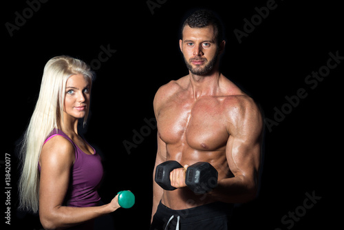 Slim fitness couple with dumbbells
