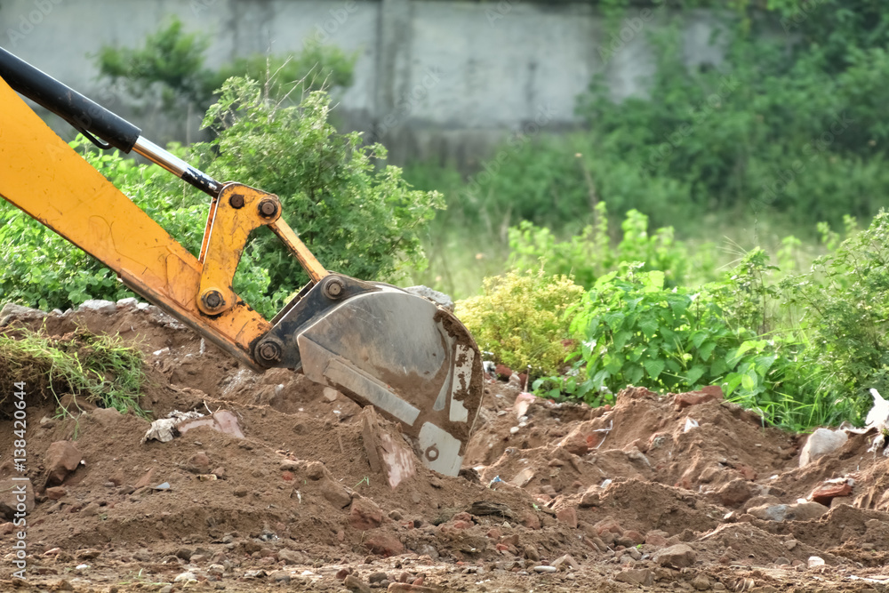 Fototapeta premium Excavator is working with dusty red soil.
