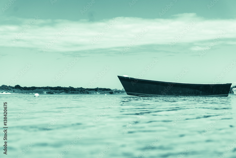 Retro style image Blue dinghy afloat on peaceful calm Ngunguru estuary Northland New Zealand