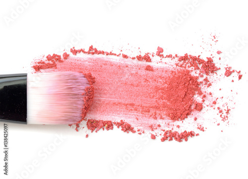 Close up of crushed blush on white background and cosmetic brush