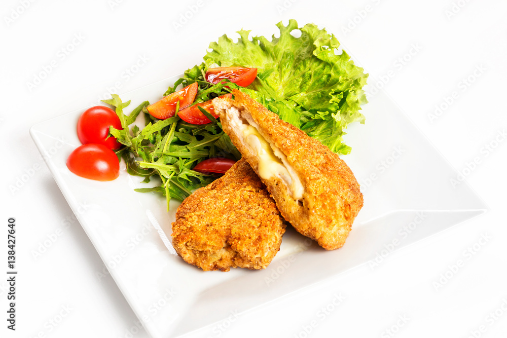 Fried golden chicken with cheese and vegetables on plate isolated at white background. Fried golden chicken with cheese and vegetables on plate isolated at white background.