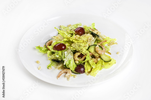 Plate of shrimps salad with soy-bean sauce and green vegetables isolated at white background.