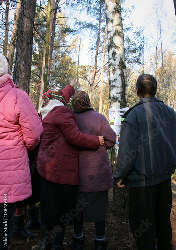 Women and men show a tree where there was a religious sign