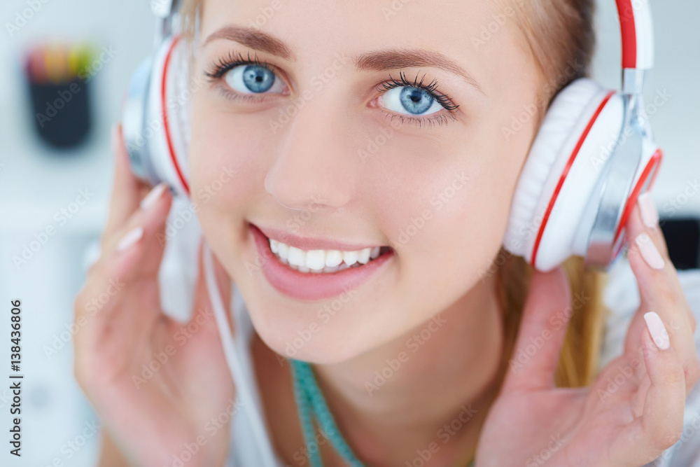 Naklejka premium Close-up portrait of young beautiful girl listening to music with pleasure.