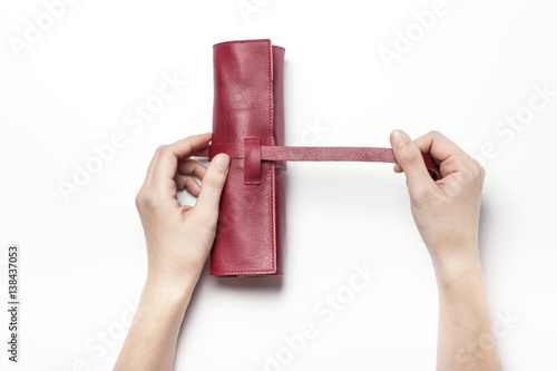 woman hand hold a red leather pencil case isolated white. photo