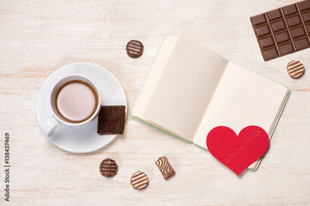 Valentines Day background with chocolate balls, coffee cup, red hearts and notebook Valentines Day background with chocolate balls, coffee cup, red hearts and notebook