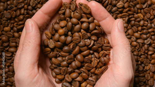 TOP VIEW  Human takes a roasted coffee beans by both hands