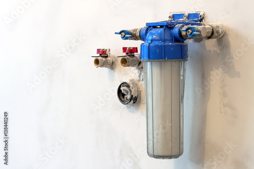 Water filter new installed on a kitchen wall to purify drinking water. photo