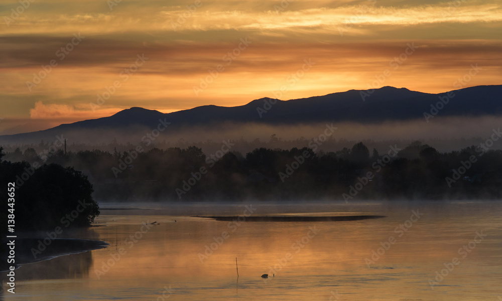 Golden sunrise over a misty river
