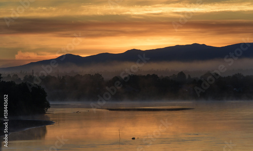 Golden sunrise over a misty river