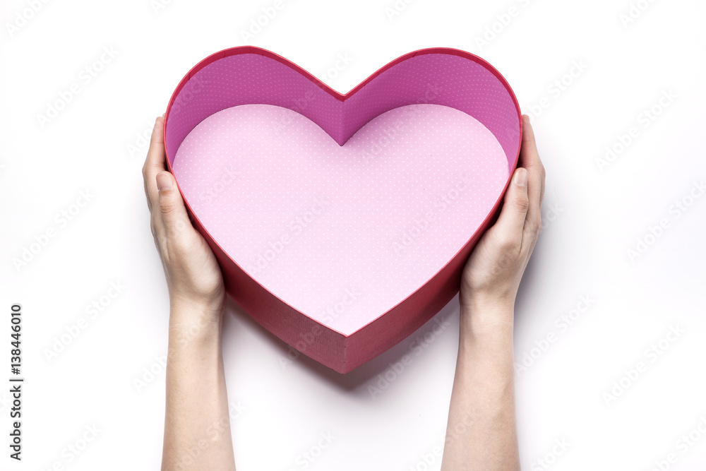 Obraz premium Woman hand hold a red heart gift box isolated white.