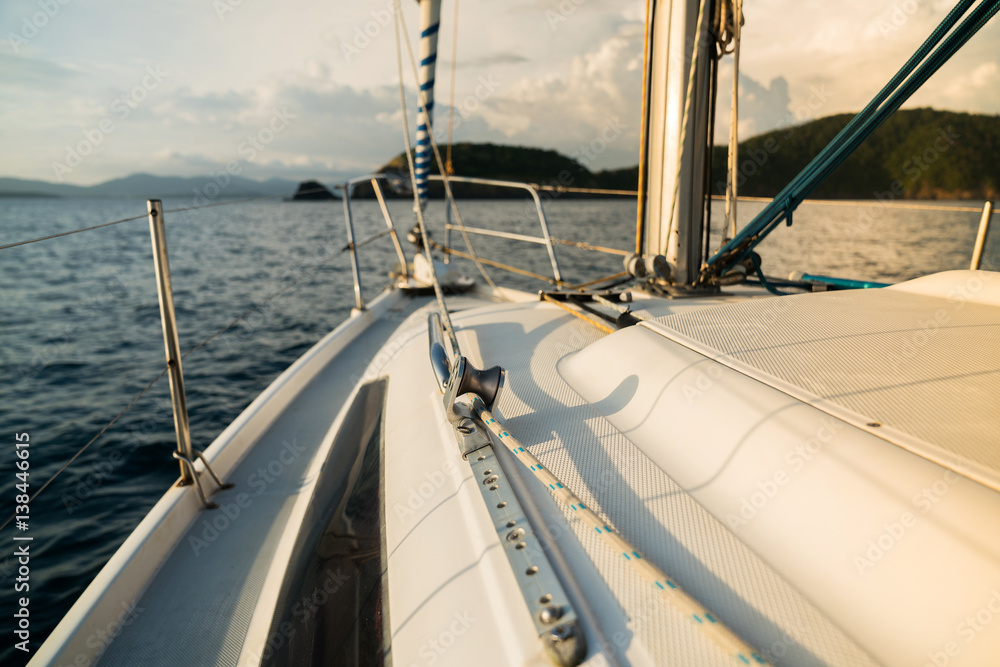 Sailing boat on the water of the ocean at sunset, and the outdoor lifestyle. Sailing boat on the water of the ocean at sunset, and the outdoor lifestyle.