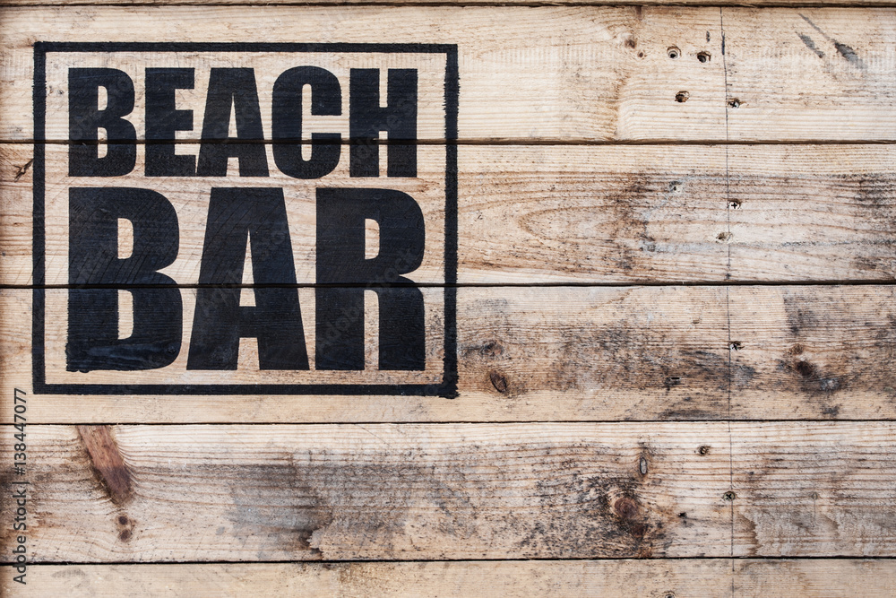 Fototapeta premium close up view of beach bar logo stamped on wooden surface