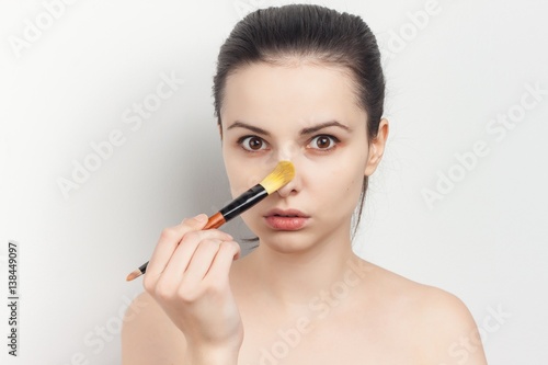 make-up brush and a woman with fair complexion