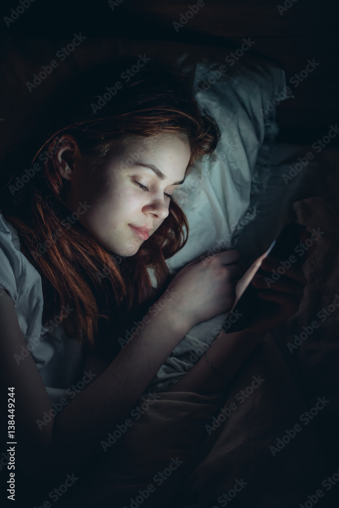 woman with phone lies on the bed woman with phone lies on the bed