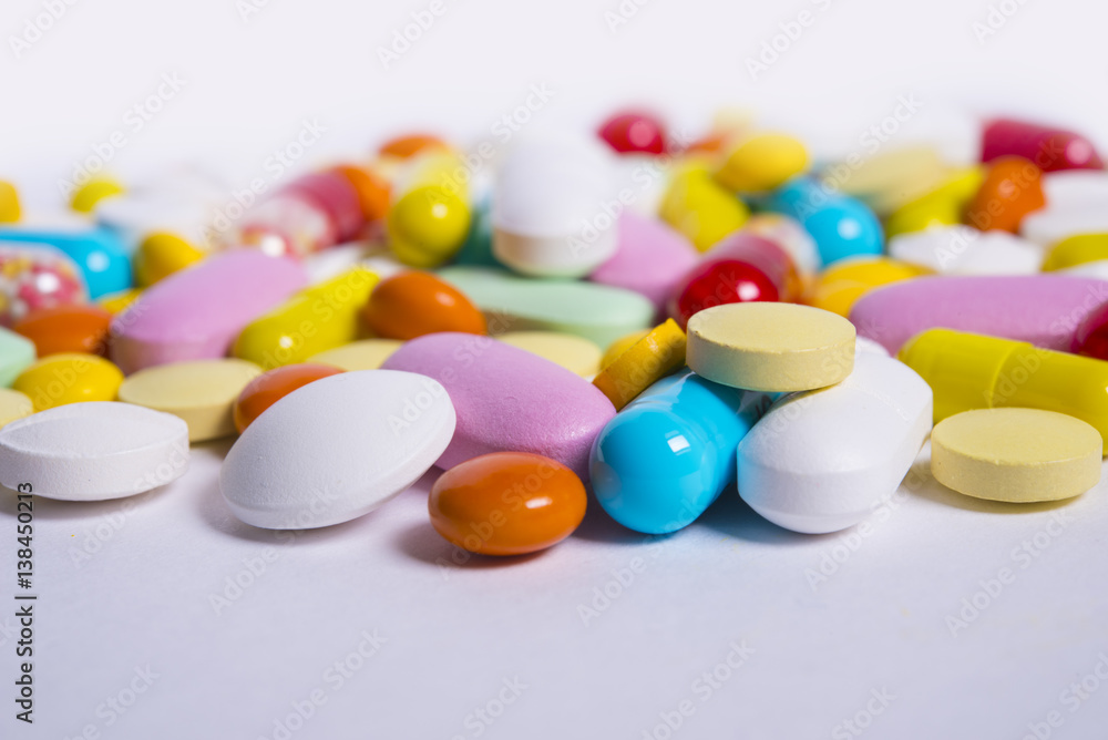 Multicolored pills and tablets on white background Multicolored pills and tablets on white background