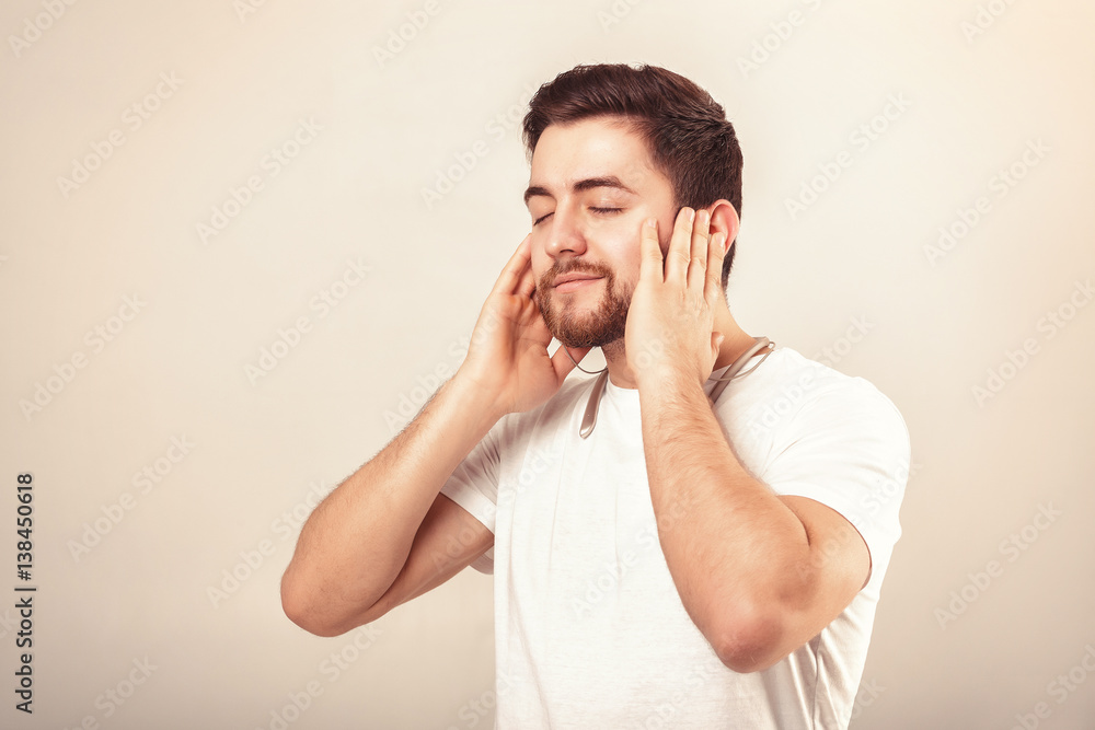 young handsome man with beard in t-shirt listening to music on headphones young handsome man with beard in t-shirt listening to music on headphones