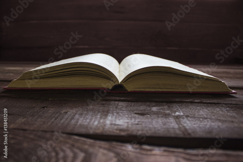 Open red book on old wooden table