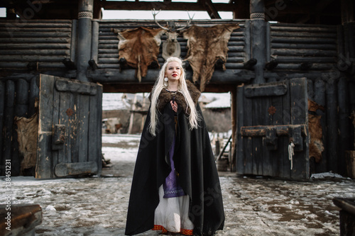 Beautiful blonde Viking dressed in a black cloak photo