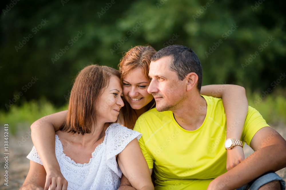 Smiling adult daughter hugging her parents. Family bonding. Smiling adult daughter hugging her parents. Family bonding.