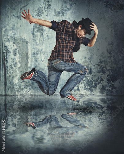 Fototapeta Naklejka Na Ścianę i Meble -  Man break dancing on wall background
