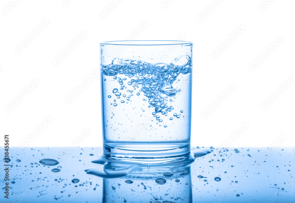 water in transparent glass with drops and bubbles isolated over white, blue background, close up water in transparent glass with drops and bubbles isolated over white, blue background, close up