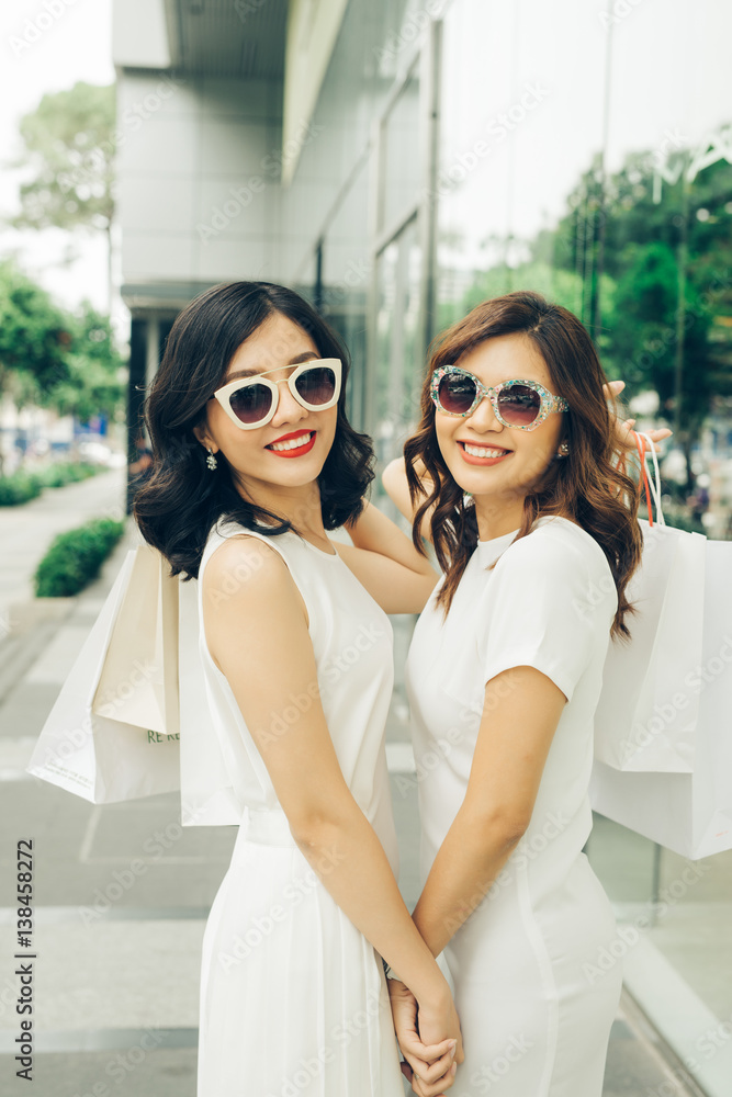 Beautiful asian girls with shopping bags walking on street at the mall