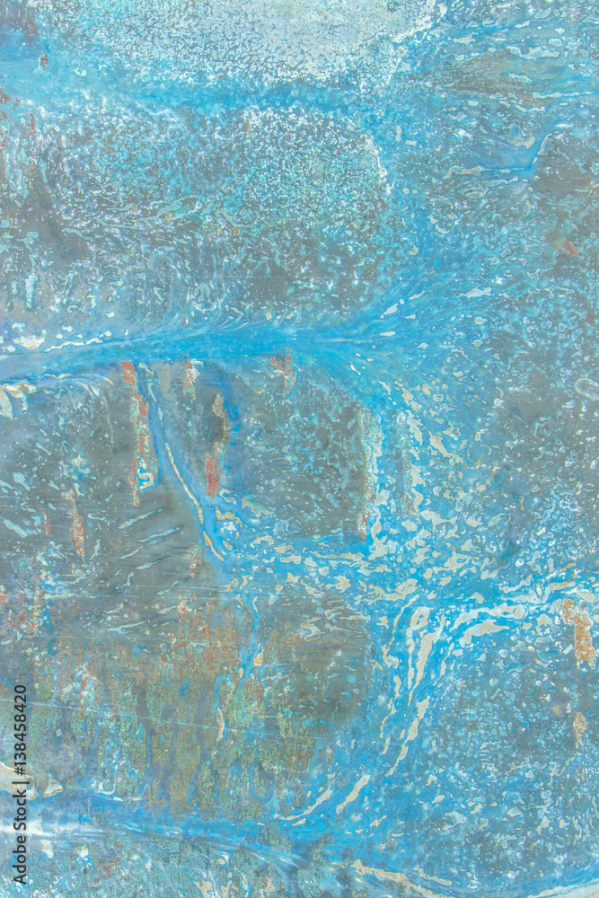 A rusty old metal plate with cracked blue gloss paint