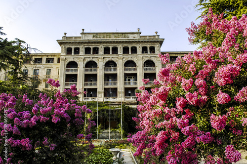 Vászonkép Portoroz, building from k.u.k. monarchy times, pink abloom plant