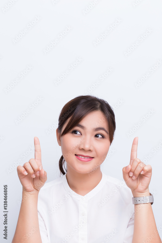 Asian woman pointing to the copy space isolated on blue background Asian woman pointing to the copy space isolated on blue background